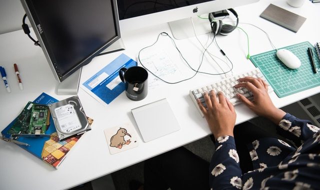 Computer repair workspace with hard drive and tools for IT support and data recovery.