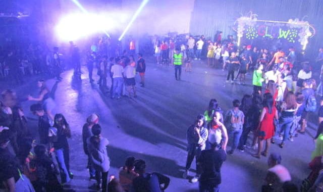 Dance party at Bali Stay beach resort with vibrant lighting and lively crowd, perfect for tropical vacation fun.