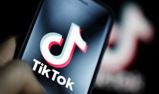 TikTok logo on smartphone screen promoting social media engagement and digital marketing.