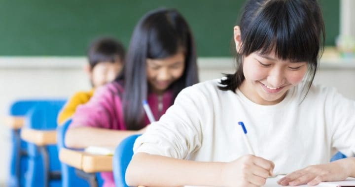 Bright schoolchildren studying in classroom, focused on learning and education.
