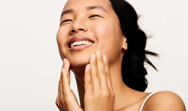 Beautiful woman enjoying skincare at Bali beach resort, tropical vacation skincare routine, relaxing Bali stay.