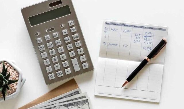 Calculator and financial documents on white desk for budgeting or accounting.