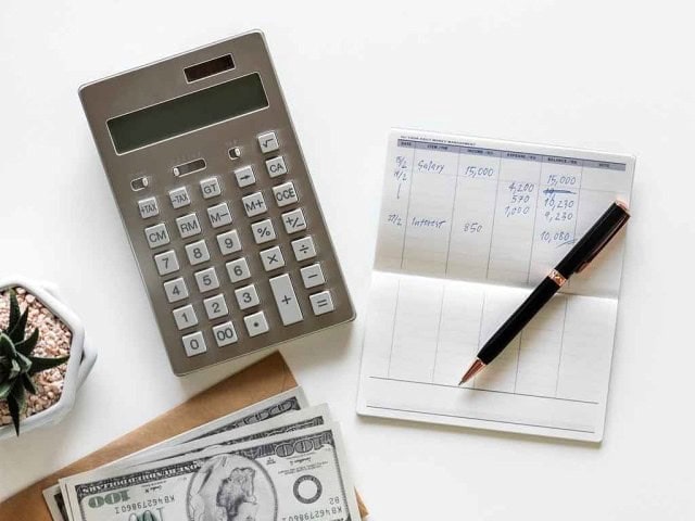 Calculator and financial documents on white desk for budgeting or accounting.